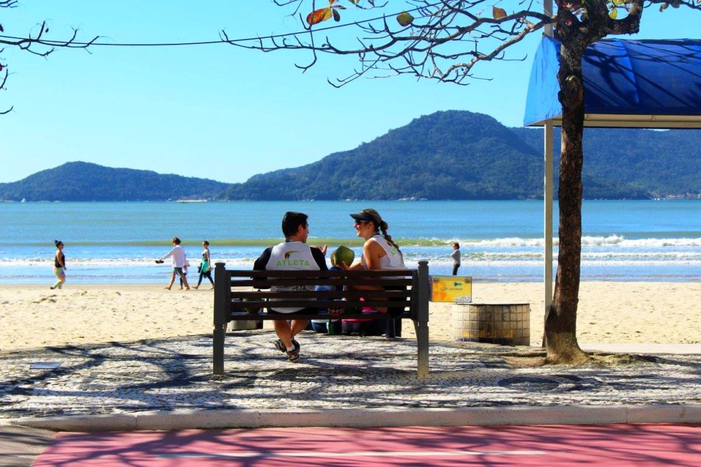 Casal bebe água de coco em dia ensolarado na Praia Central de Balneário Camboriú em Santa Catarina (Foto: La Viagem)