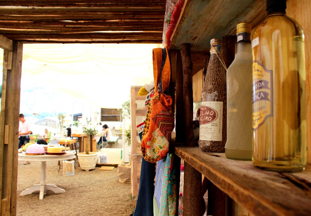 Fileira de produtos fabricados na Fazenda Maria da Fé e ao fundo o restaurante. (Foto: La Viagem)