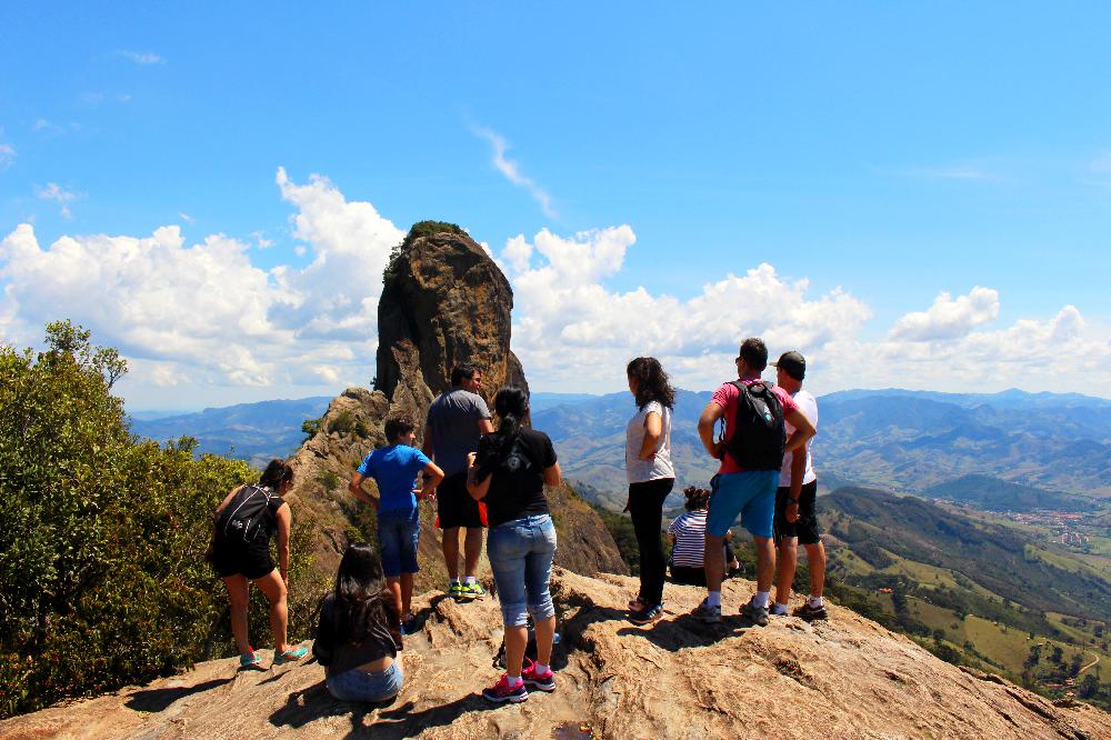 Na Pedra do Bauzinho um grupo de pessoas e ao fundo, a Pedra do Baú. (Foto: La Viagem)